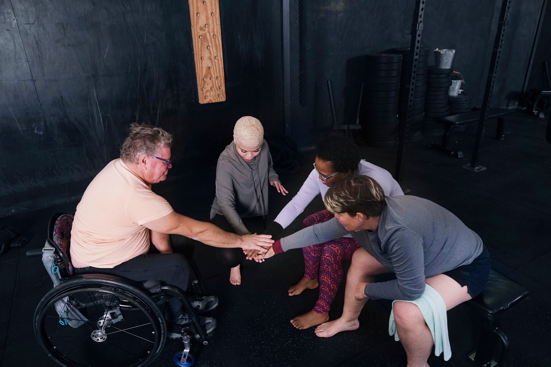 Friends stacking hands in gym